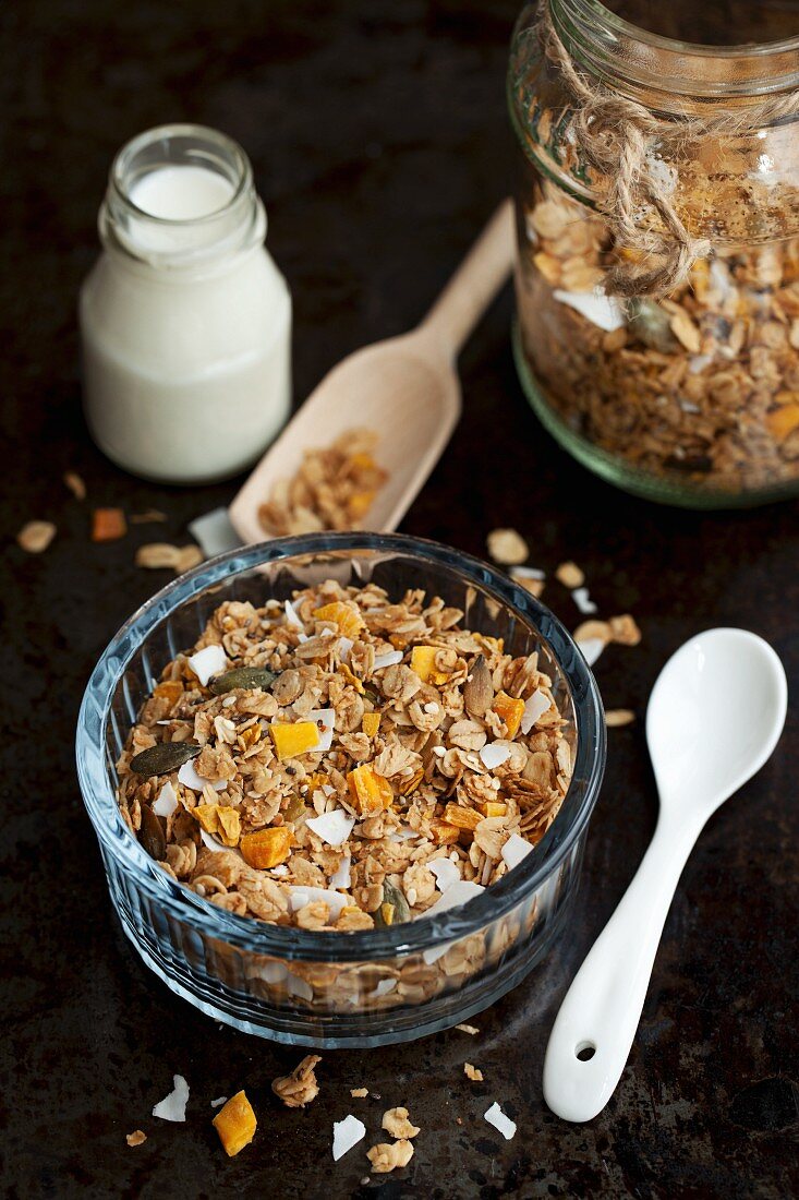 A bowl of muesli and a bottle of milk