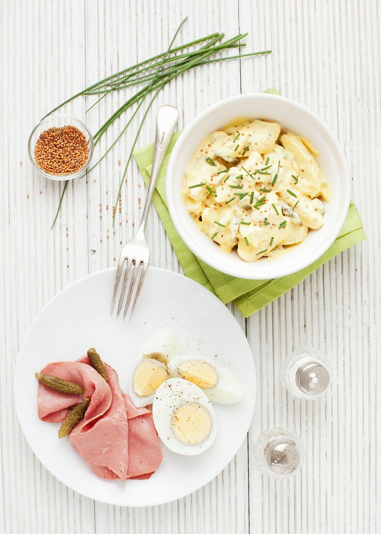 Potato salad and pastrami with egg and gherkins