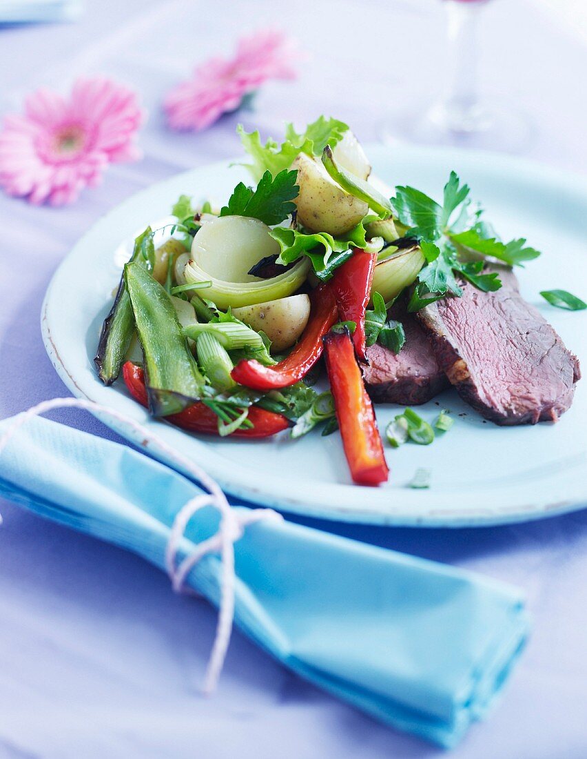 Roastbeef mit gebratenen grünen und roten Paprikaschoten, Kartoffeln, Zwiebeln und Petersilie