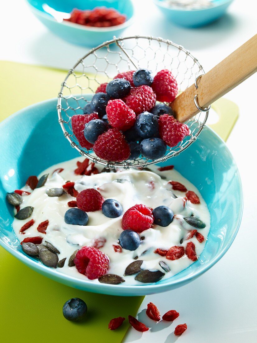 Yoghurt muesli with raspberies, blueberries, goji berries and pumpkin seeds