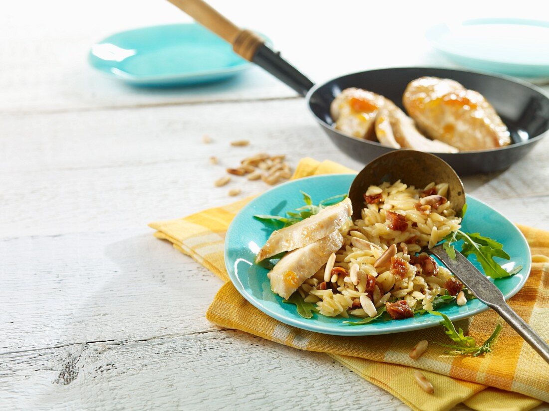 Noodle risotto with chicken, dried tomatoes and pine nuts