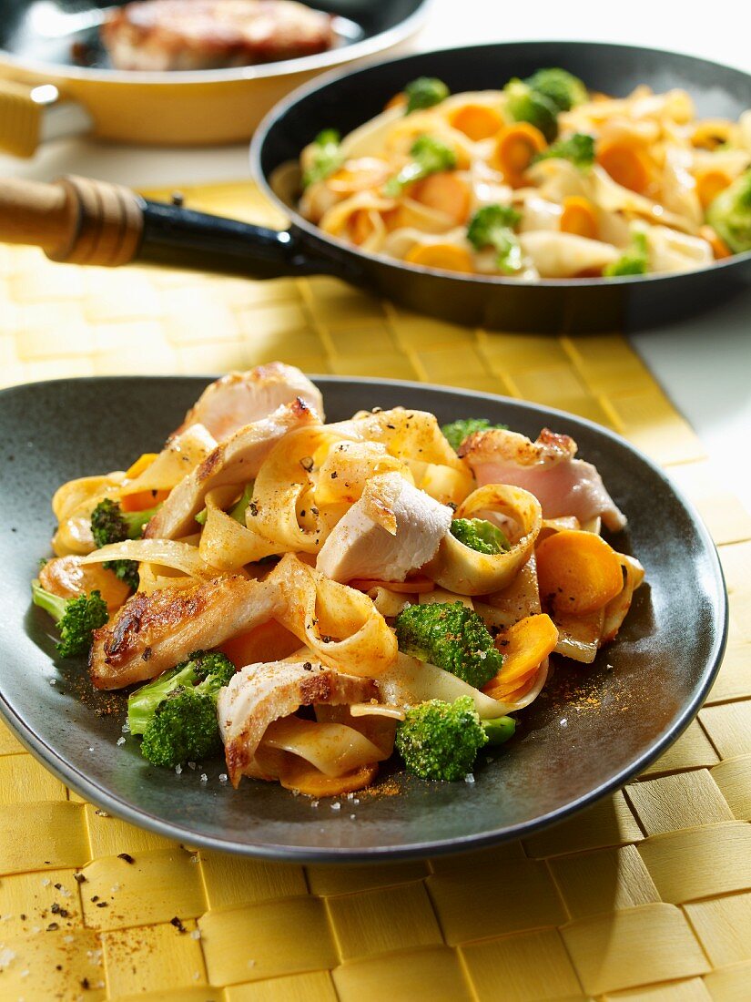 Fried noodles with chicken, carrots and broccoli