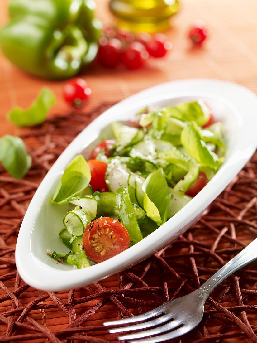 Pepper and cucumber salad with cherry tomatoes and basil