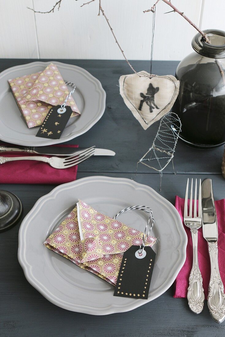 Table set for Christmas with napkins folded in shaped of envelopes and hand-crafted labels