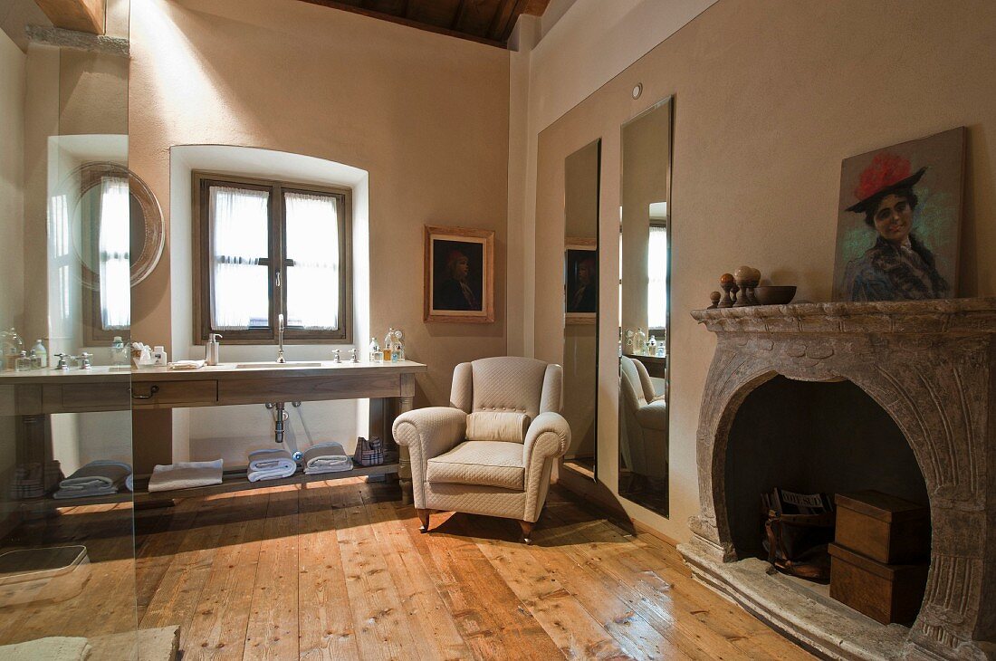 Spacious bathroom with pale armchair and fireplace