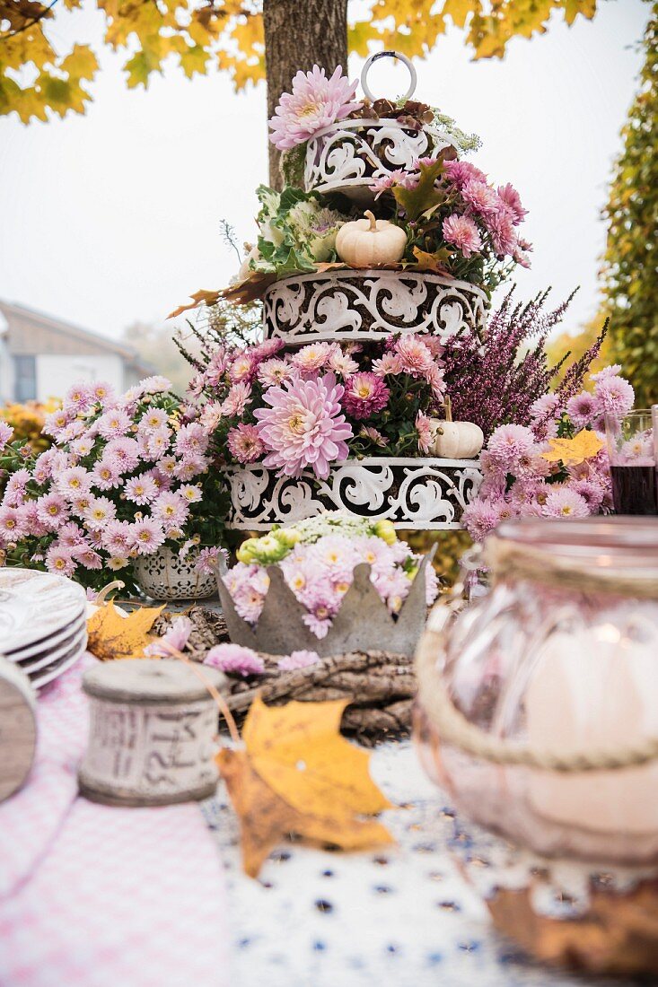 Autumnal arrangement of flowers on cake stand on set table