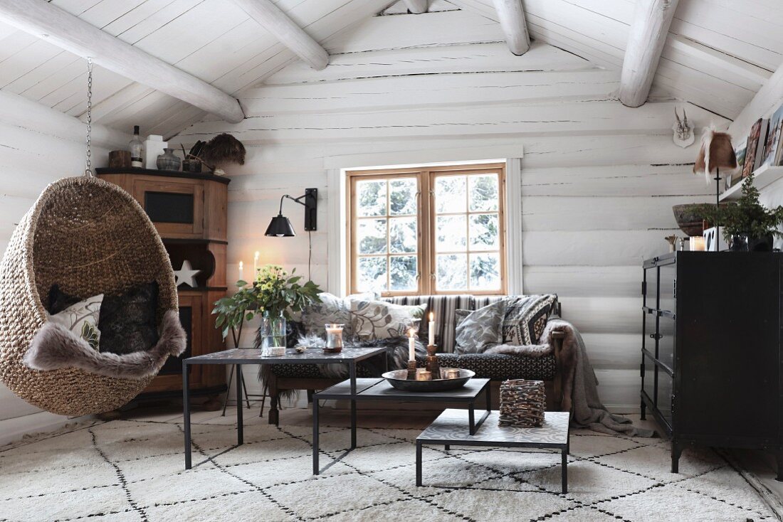 Gemütliches Wohnzimmer mit Hängesessel in einer Blockhütte