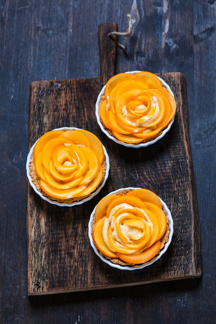 Almond tartlets with persimmon shaped as roses