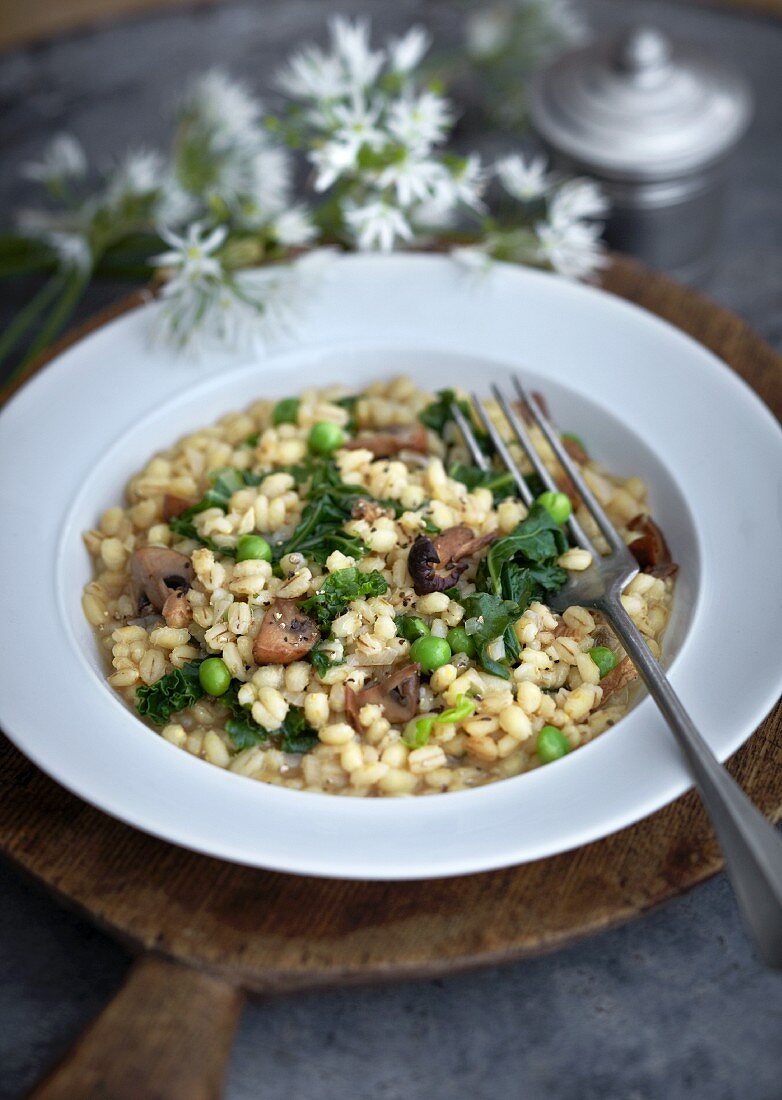 Barley risotto with mushrooms, peas and kale