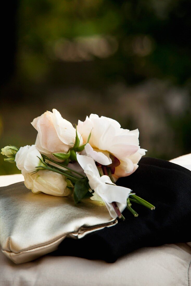 Bouquet of pale pink roses on a gold evening purse