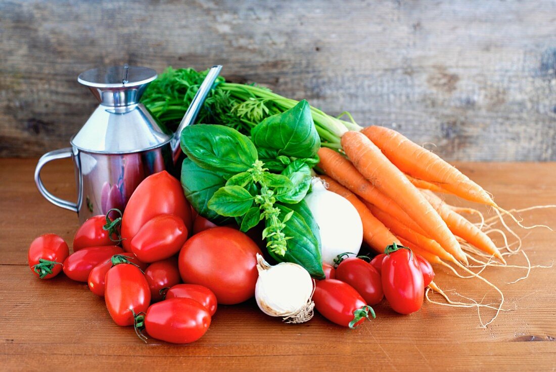 Zutaten für italienische Tomatensauce (Basilikum, Tomaten, Karotten, Zwiebeln, Knoblauch und Olivenöl)