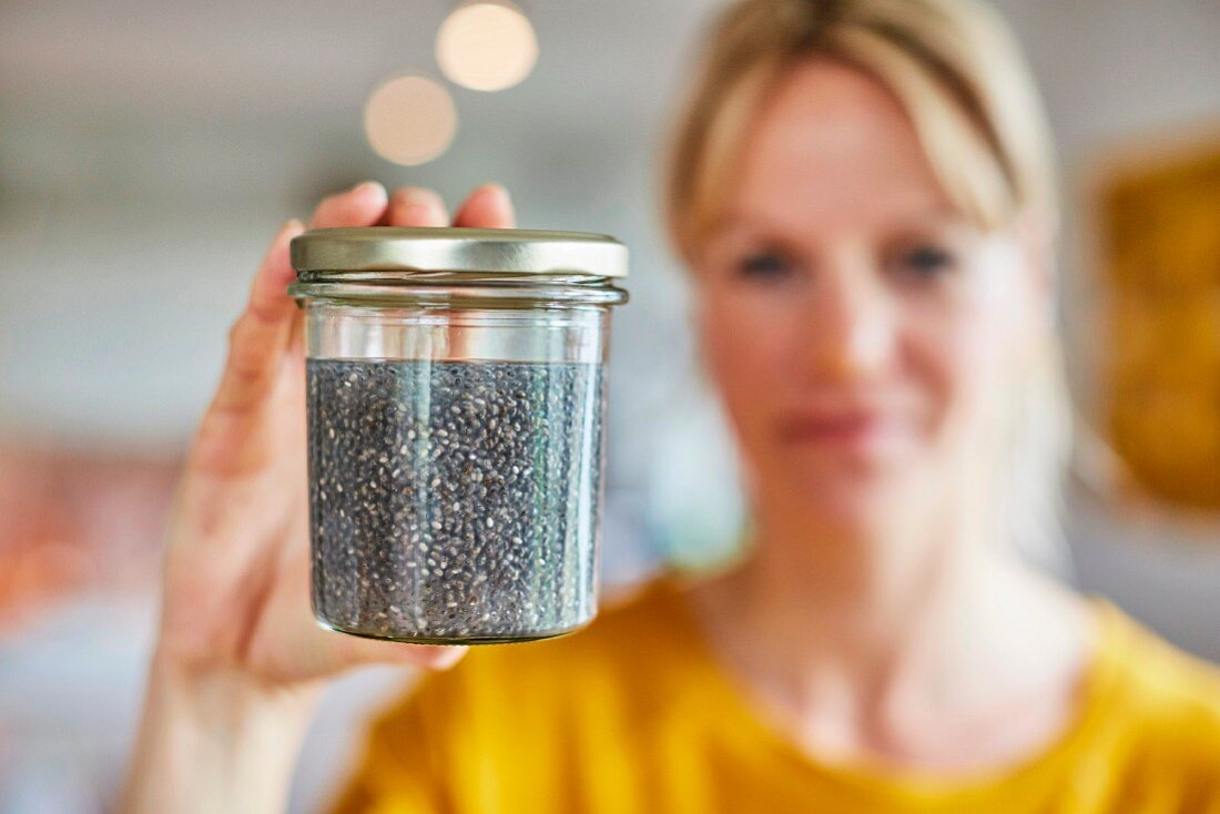A woman holding a jar of seeds
