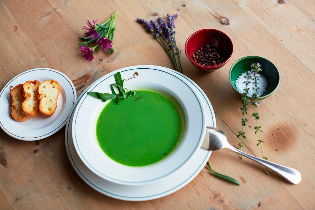 Green herb soup, bread, salt, pepper and fresh herbs