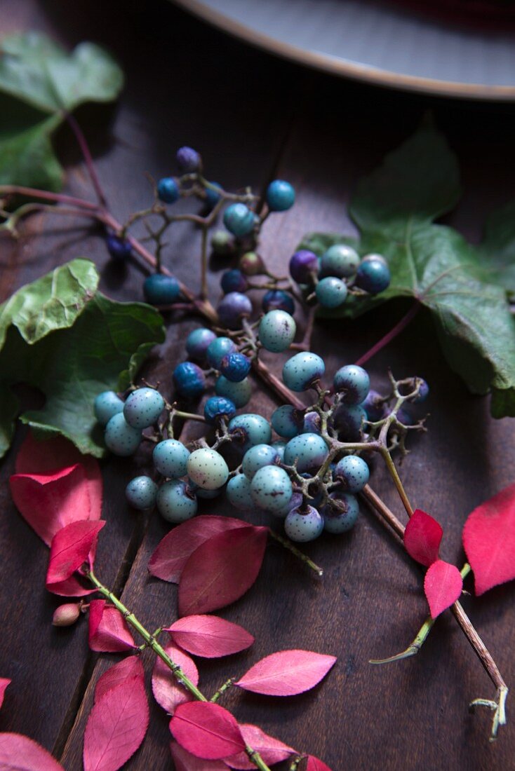 Türkisblaue Beeren & Herbstlaub als Tischdekoration