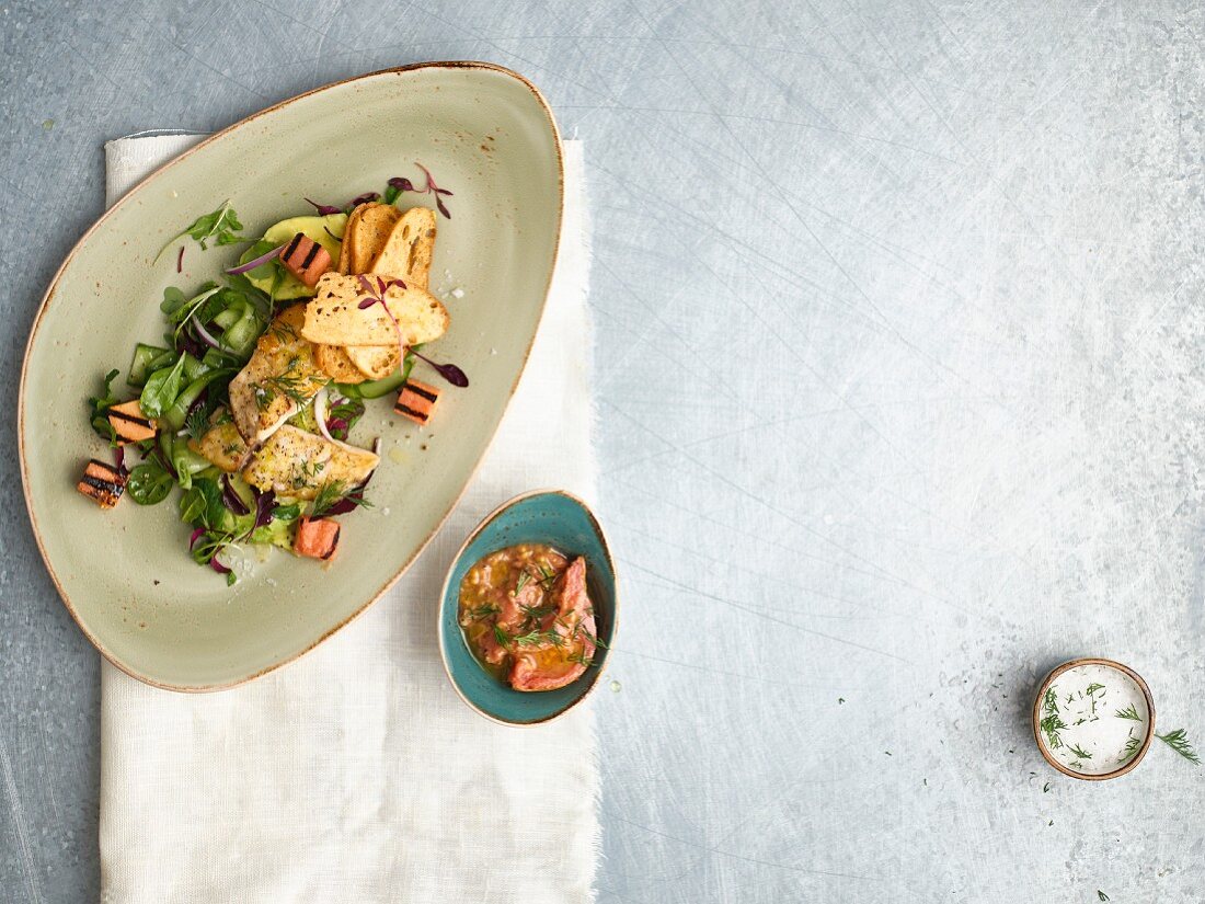 Kabeljau auf grünem Salat mit Guavenwürfeln und Röstbrot