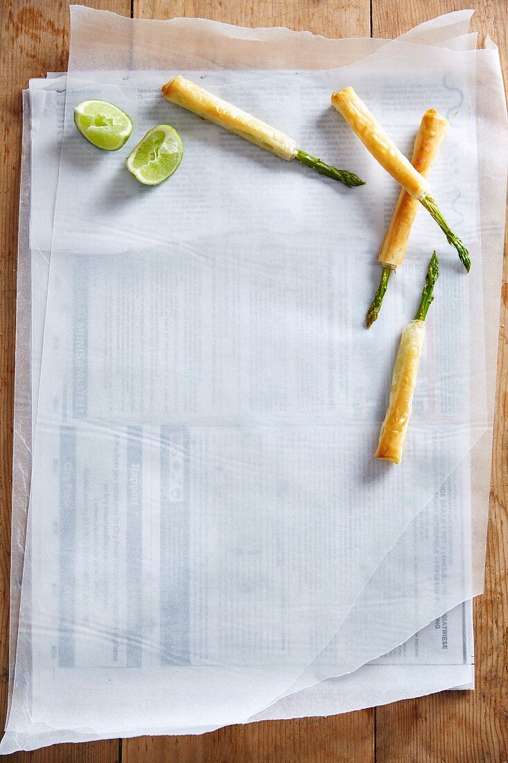 Asparagus spears in filo pastry on a piece of white paper
