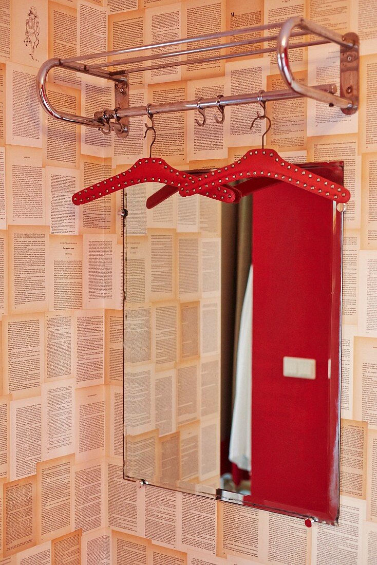 Retro Garderobe aus Metall vor Spiegel an tapezierter Wand