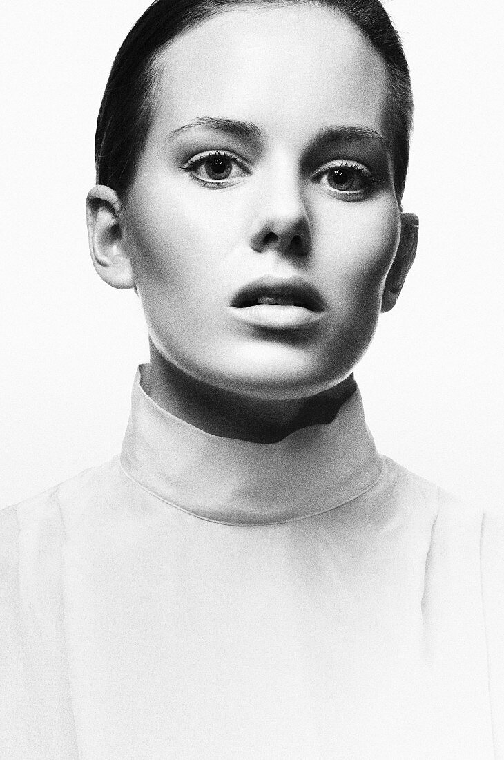 A young woman wearing a white roll-neck top