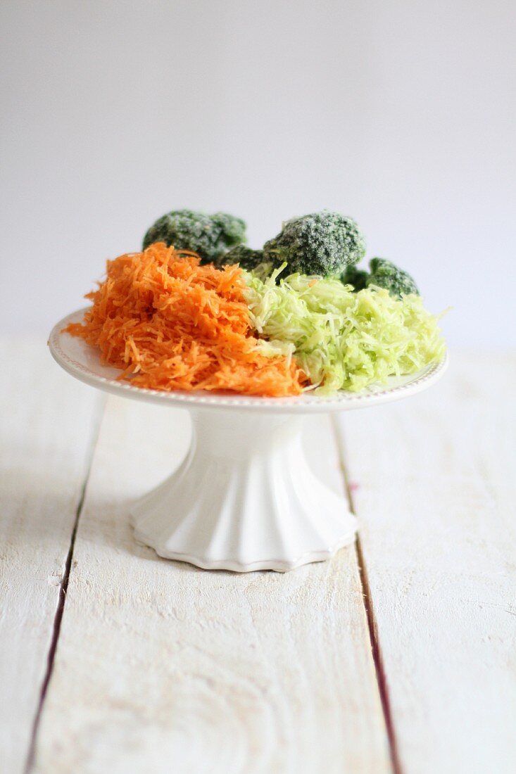 Grated vegetables on a white cake stand
