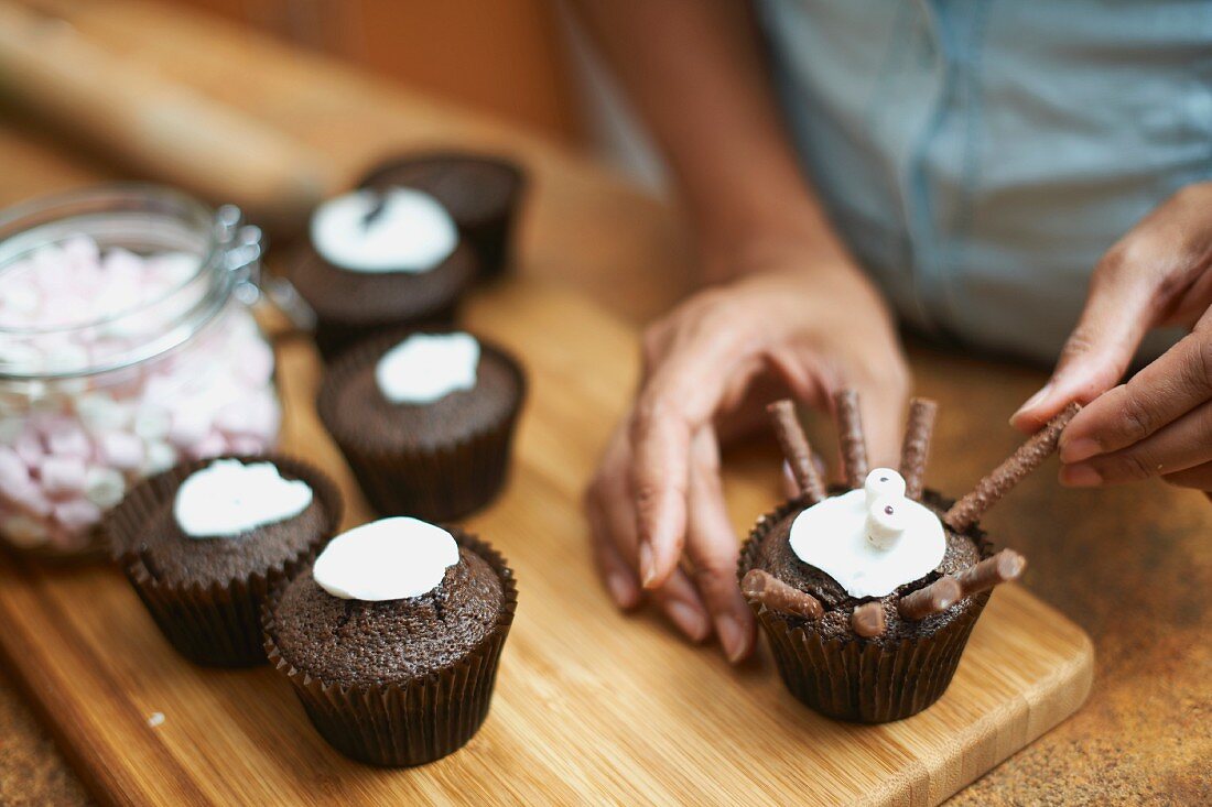 Person verziert Cupcakes