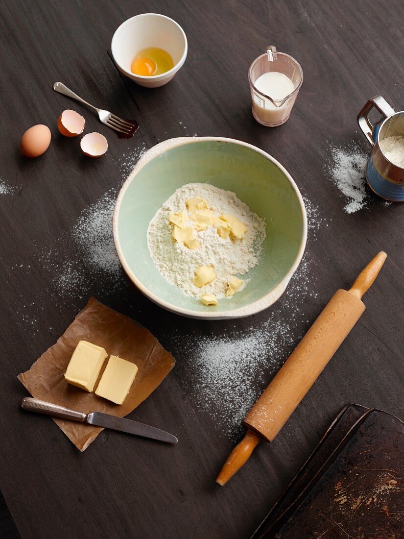 A mixing bowl with baking ingredients and baking utensils (seen from above)