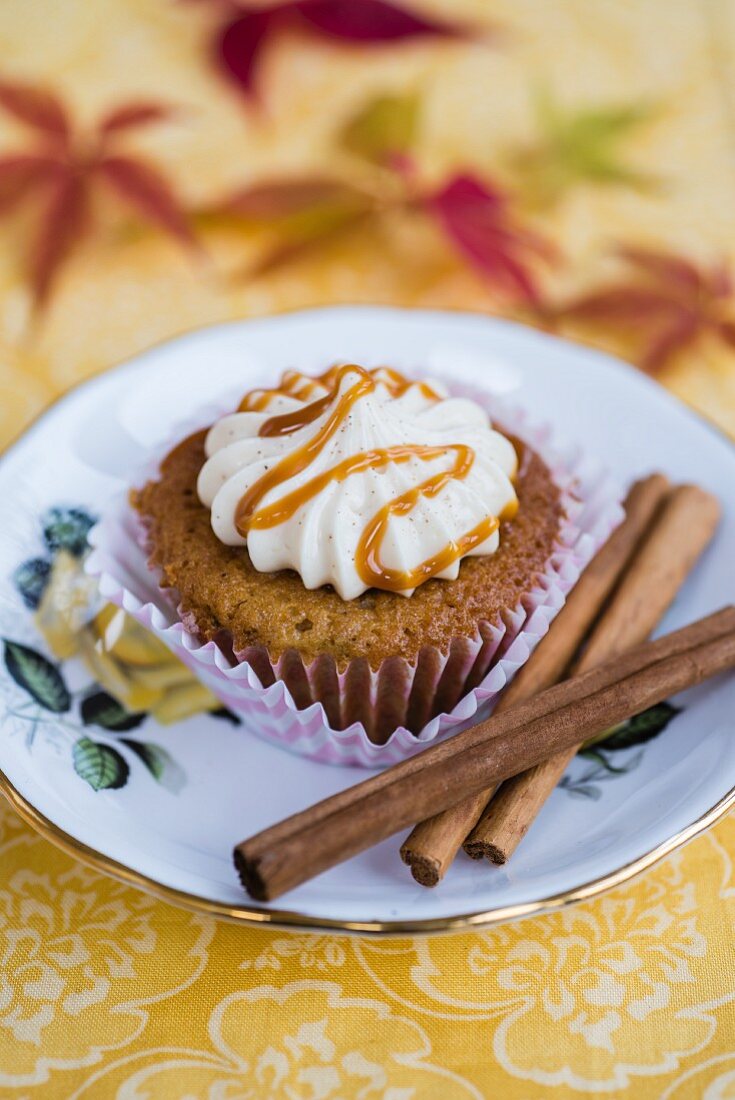 A pear and spice cupcake with cream cheese frosting and caramel