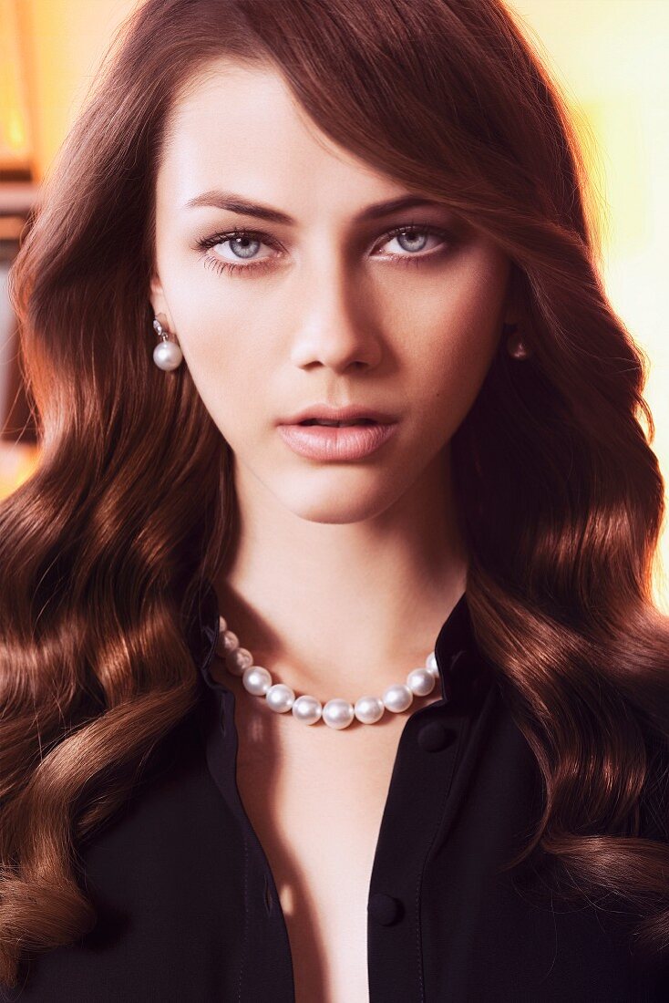 A young brunette woman wearing pearls