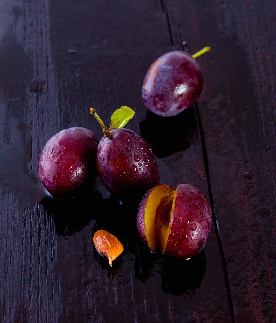 Freshly washed damsons on a wooden surface