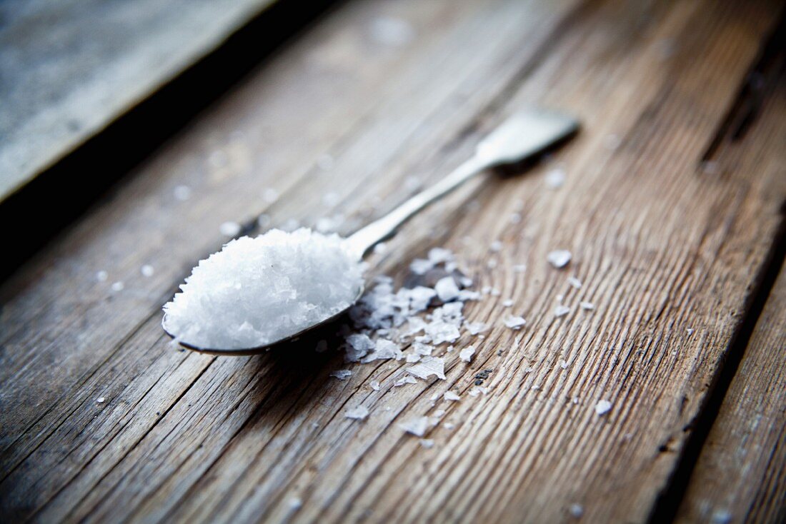 Flakes of sea salt on a silver spoon