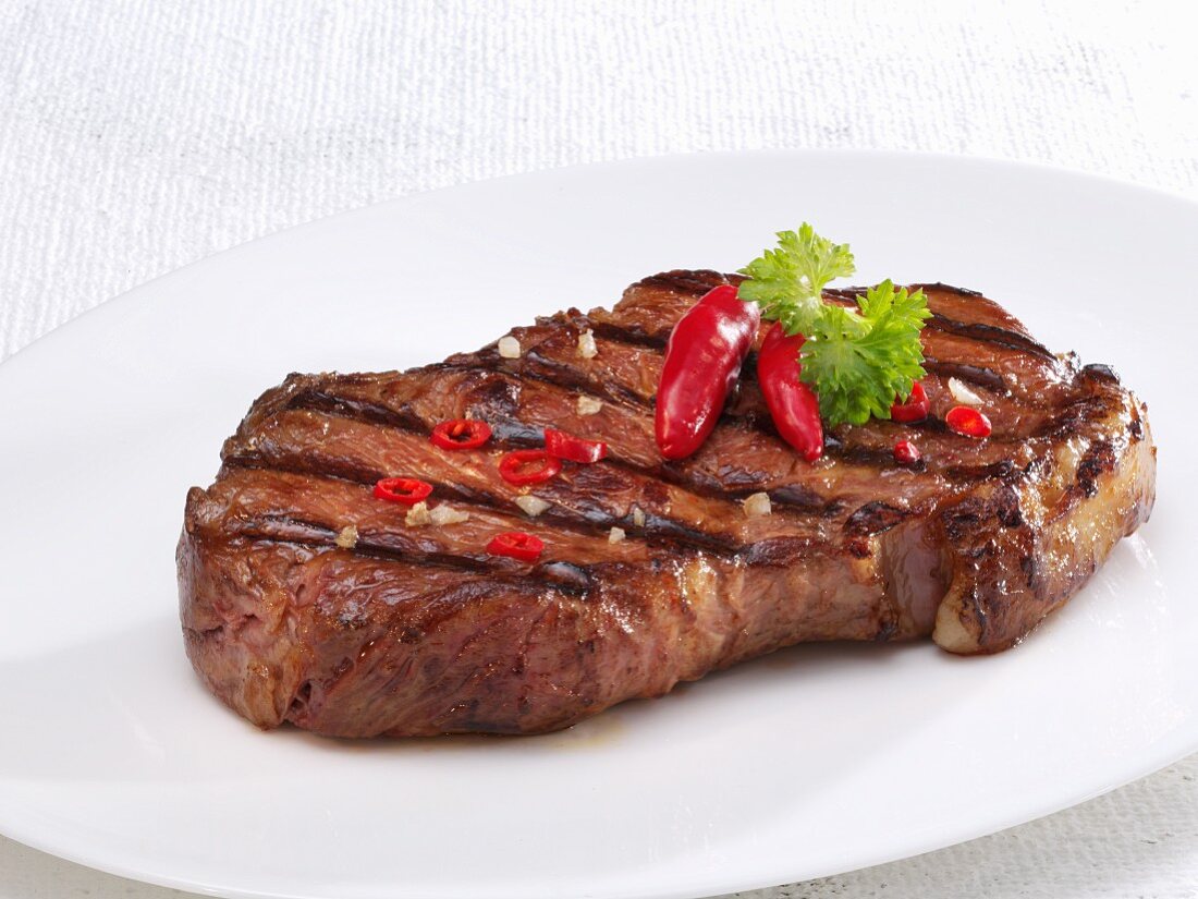 A fried beef steak with chilli peppers