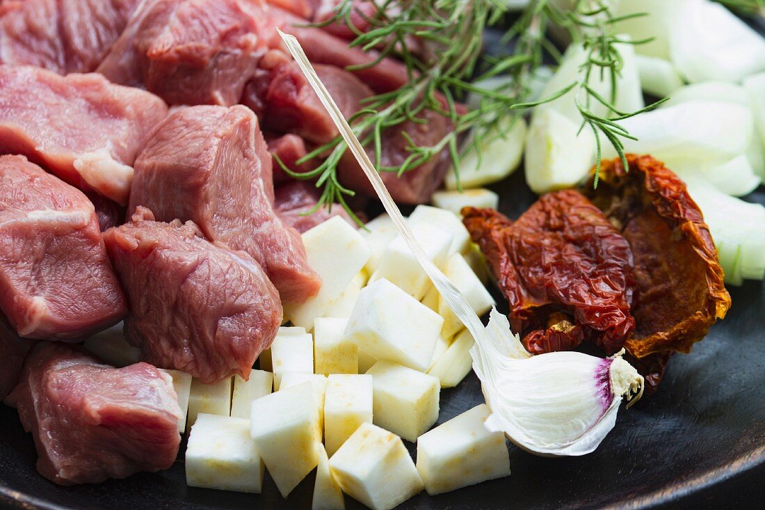 Gewürfeltes Schweinefleisch mit Gemüsewürfeln und Kräutern, zum Braten vorbereitet