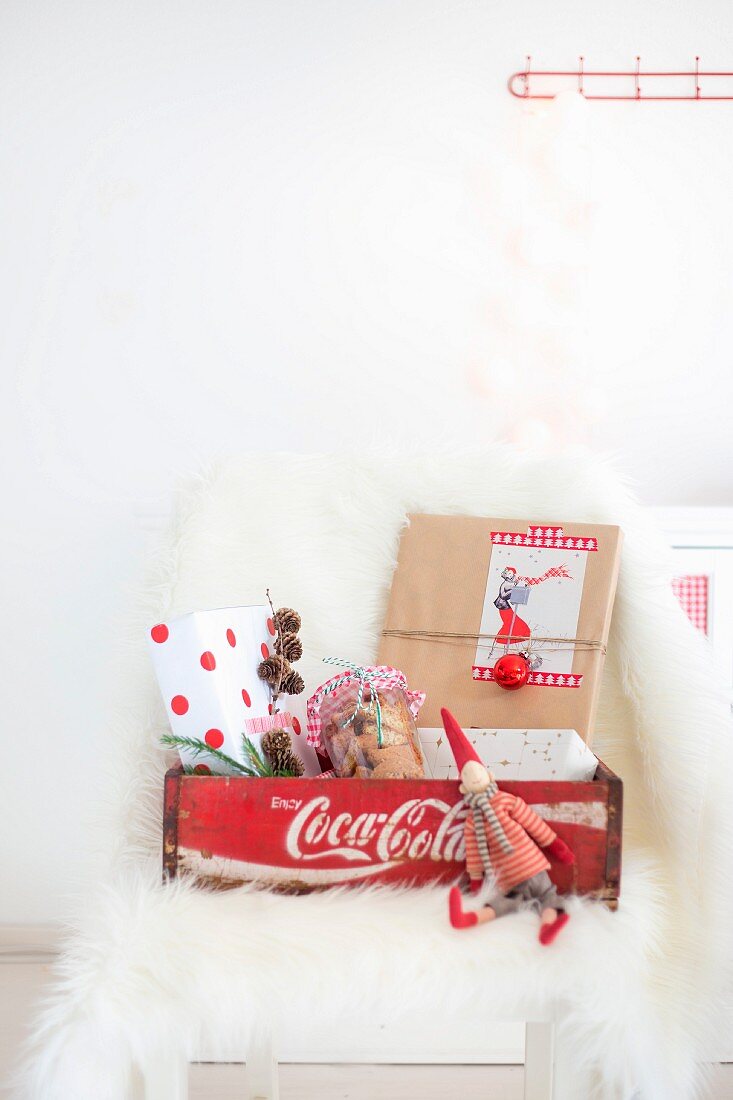 Christmas elf and wrapped presents in labelled wooden crate