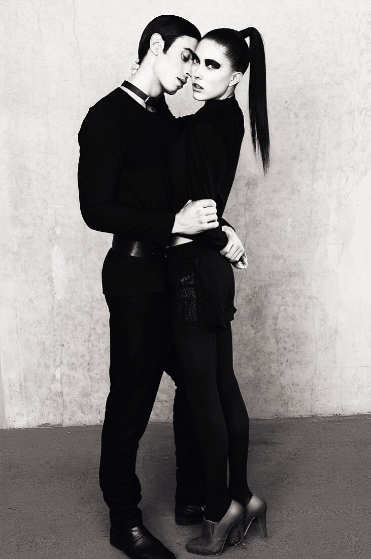 Junges Paar in schwarzer Kleidung umarmt sich (s/w-Bild)