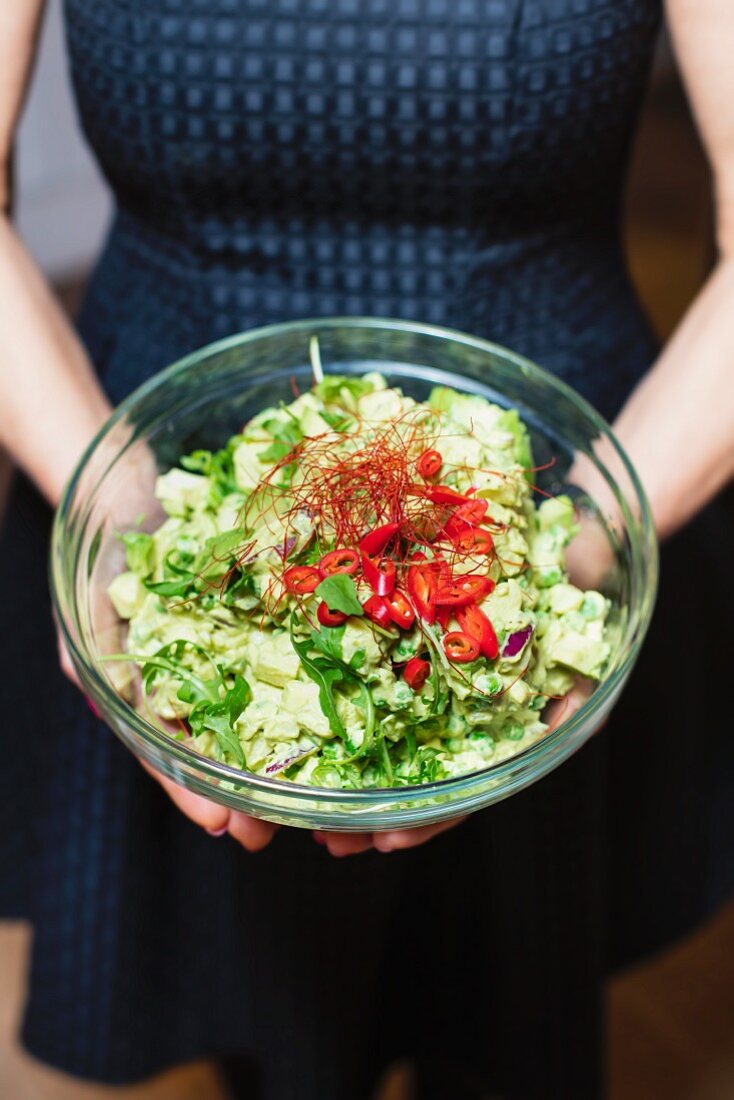 Frau hält eine Schüssel Kartoffelsalat mit Chilischoten