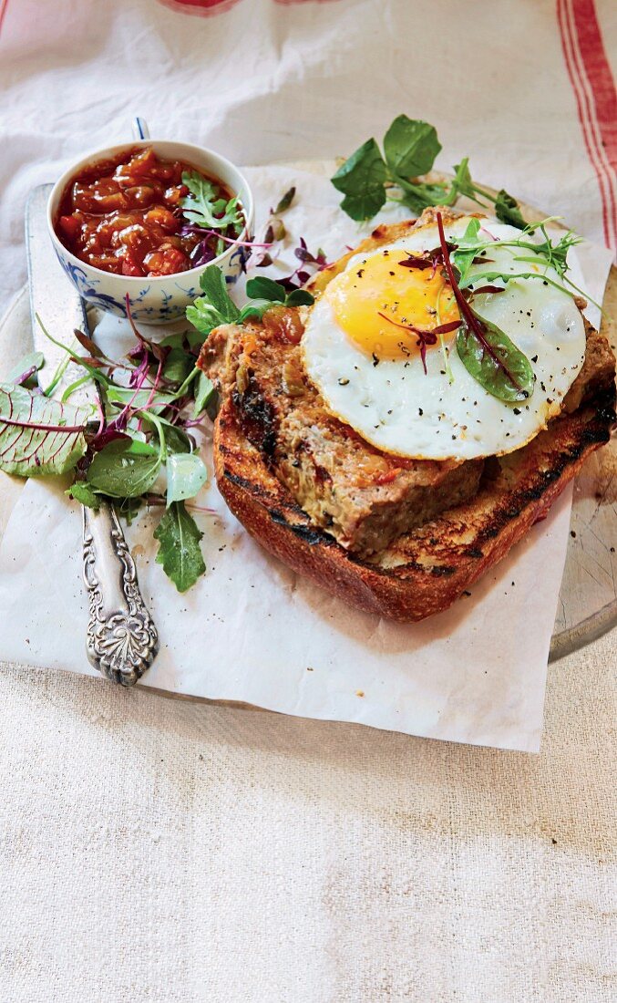 Grilled bread topped with meatloaf and a fried egg