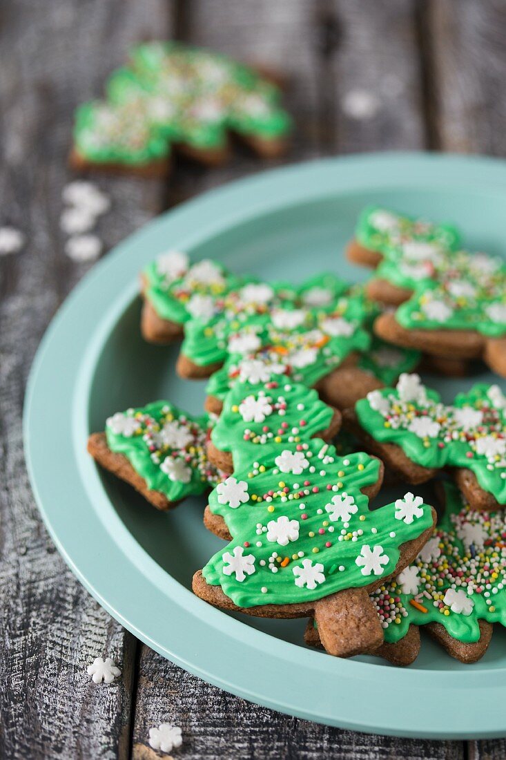 Lebkuchen-Weihnachtsbaum-Cookies mit grüner Zuckerglasur auf Teller