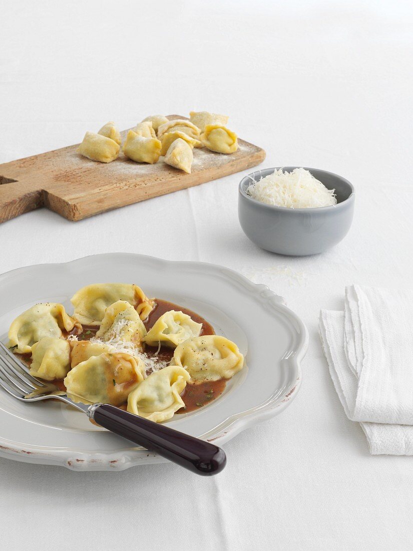 Agnolotti ripieni mit Sauce und geriebenem Käse