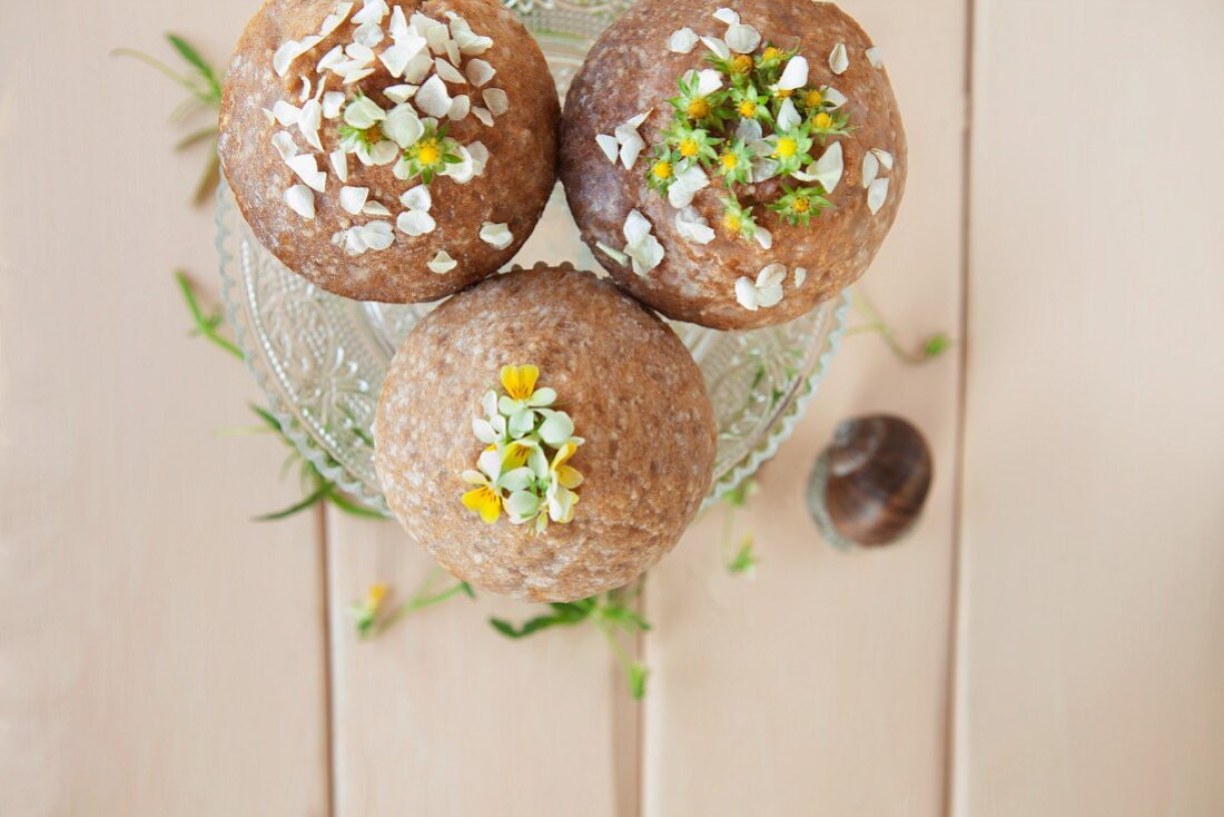 Vanilla muffins with wild flowers on a pastel coloured wooden table