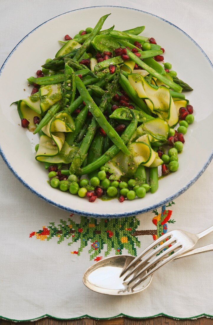 A plate of green vegetables with pomegranate seeds fro Christmas