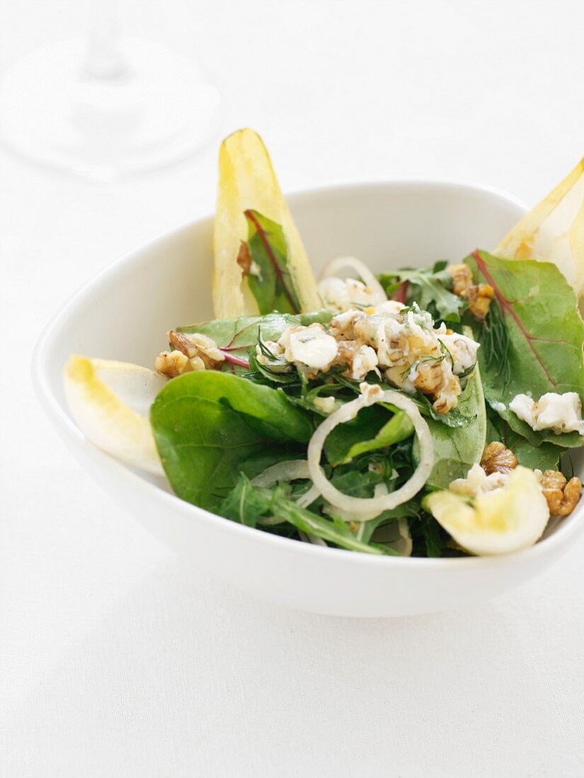 Grüner Salat mit Nüssen, Zwiebeln und Dressing