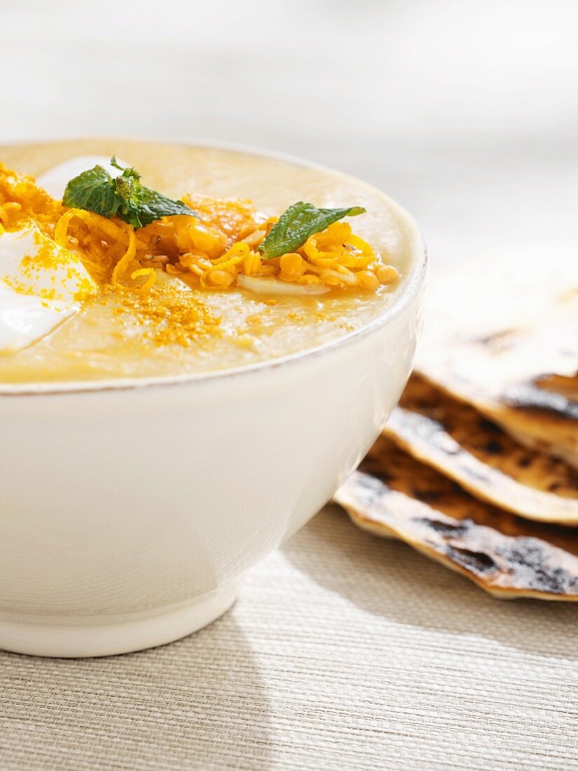 Pumpkin soup with grated cheese and naan bread