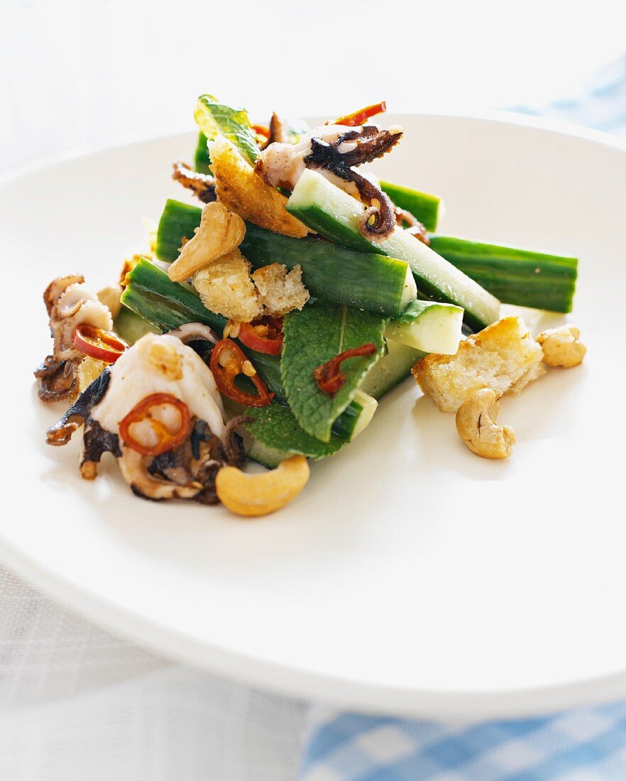Octopus salad with cucumber, cashew nuts and croutons