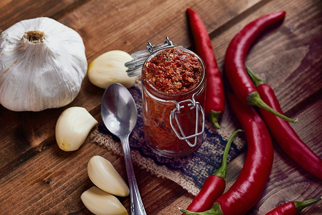 A jar of chilli paste surrounded by ingredients