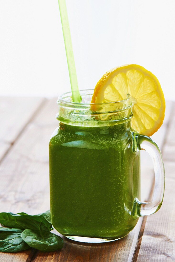 A green smoothie with a slice of lemon