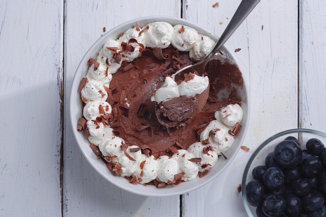 Chocolate ice cream with cream and blueberries