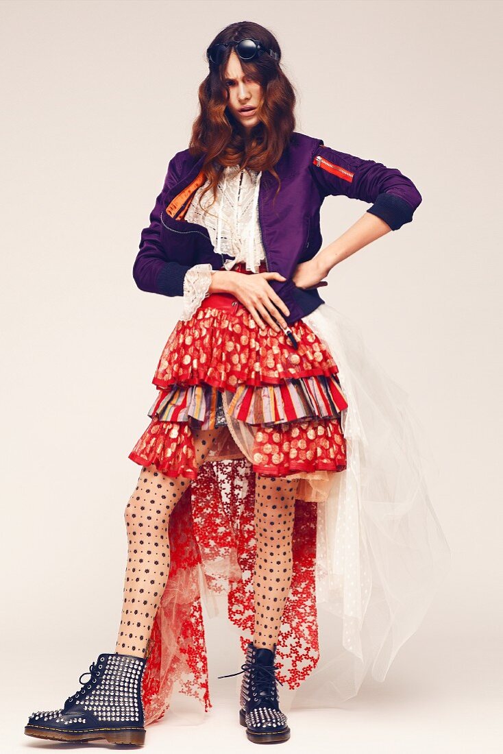 A young woman wearing a blouse, a jacket and a colourful, frilly skirt with tulle