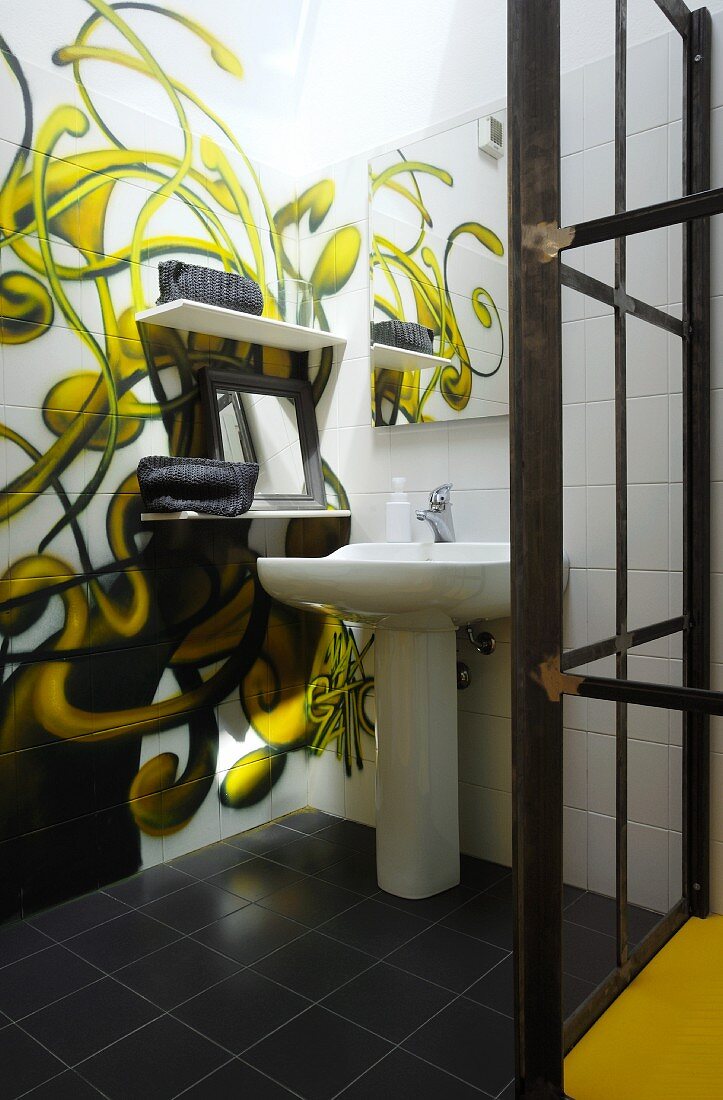 Wandbild mit Schlingpflanzenmotiv auf weissen Fliesen und Standwaschbecken im Badezimmer