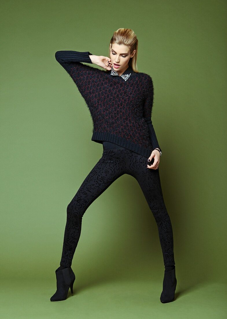 A blonde woman wearing a black jumper and leggings