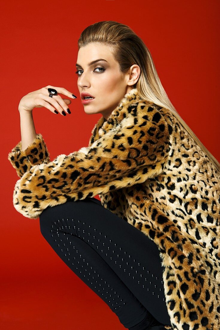 Blonde Frau mit Mantel im Leoparden-Look und schwarzer Hose