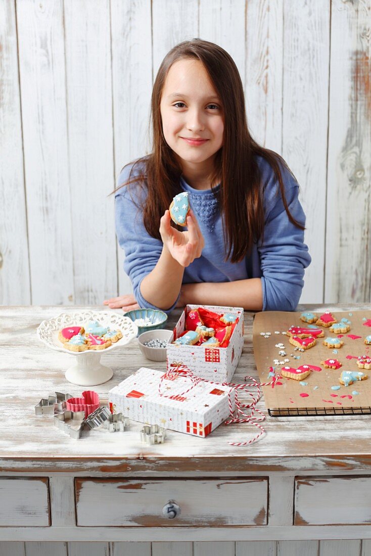 Mädchen zeigt ihre selbstgebackenen Weihnachtsplätzchen